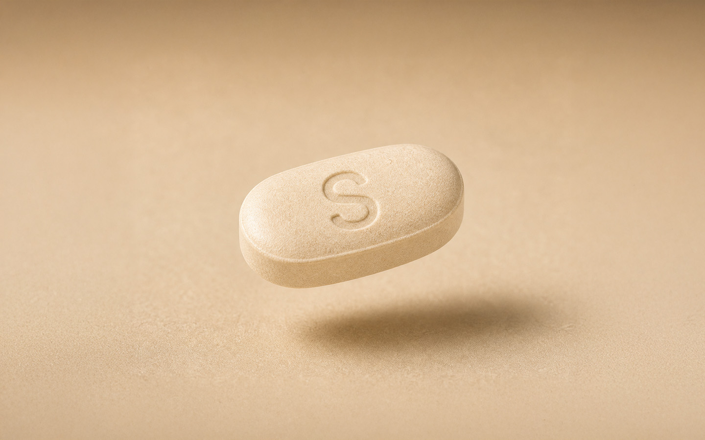Oral semaglutide tablet on a warm neutral background